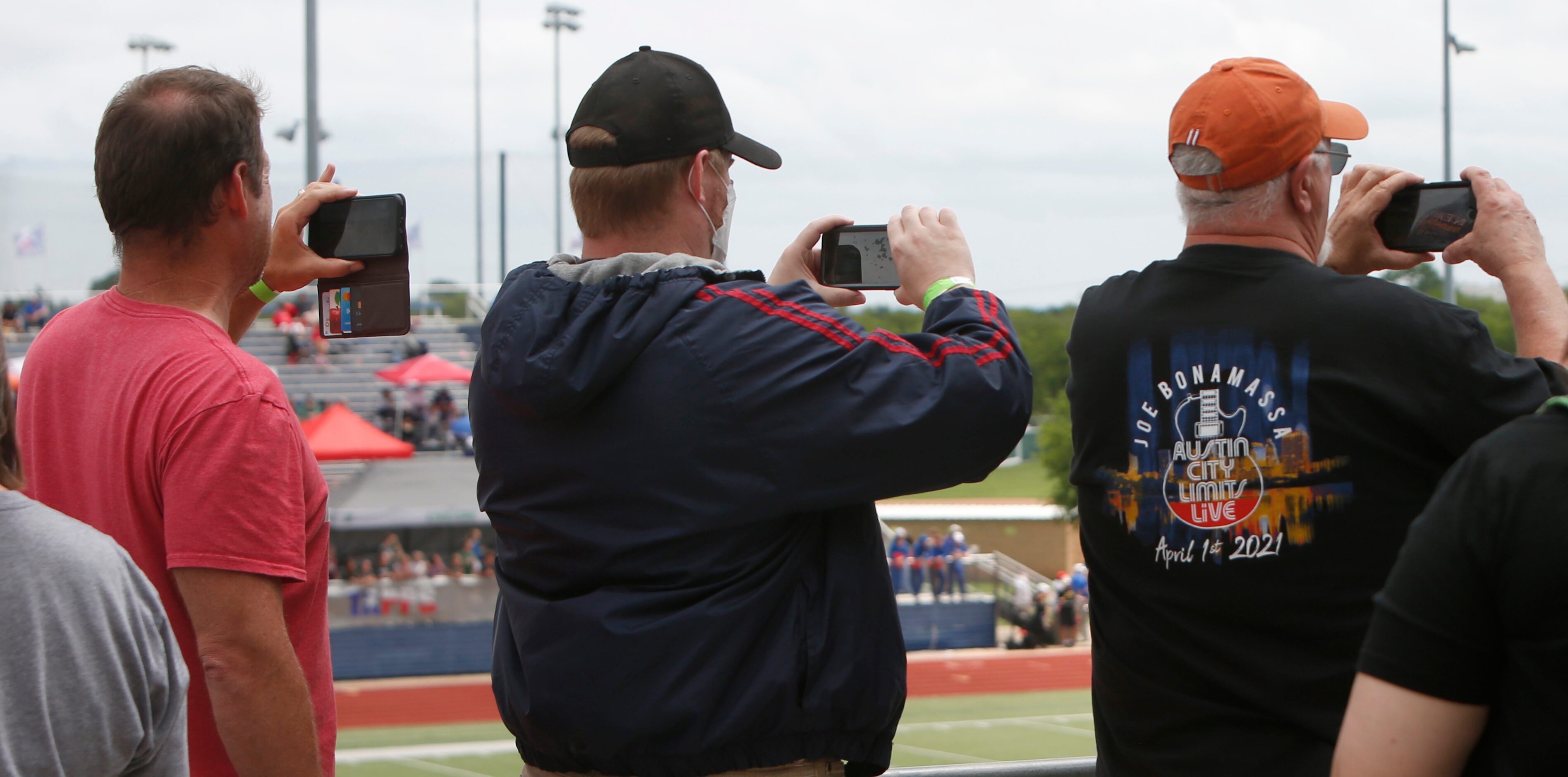 Track supporters are poised to record the start of a race from the stands. The running...