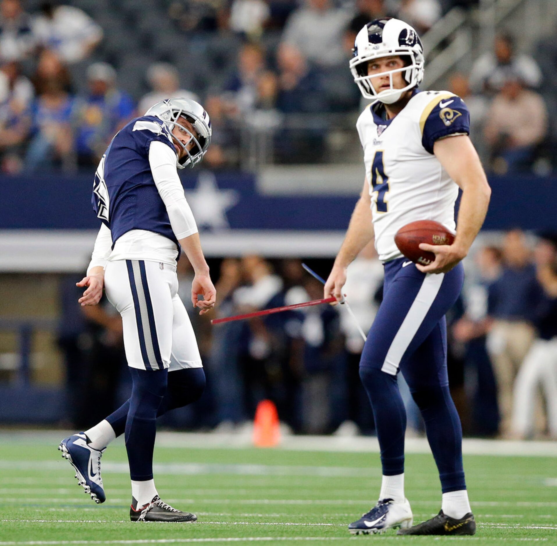 Los Angeles Rams kicker Greg Zuerlein (4) watches Dallas Cowboys kicker Kai Forbath's (3)...