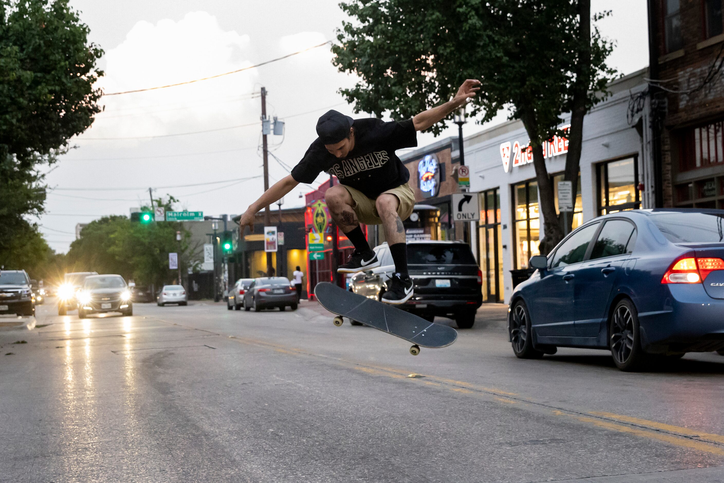 Edwin Aguilar performs a trick on his skateboard on Main Street in the Deep Ellum district...