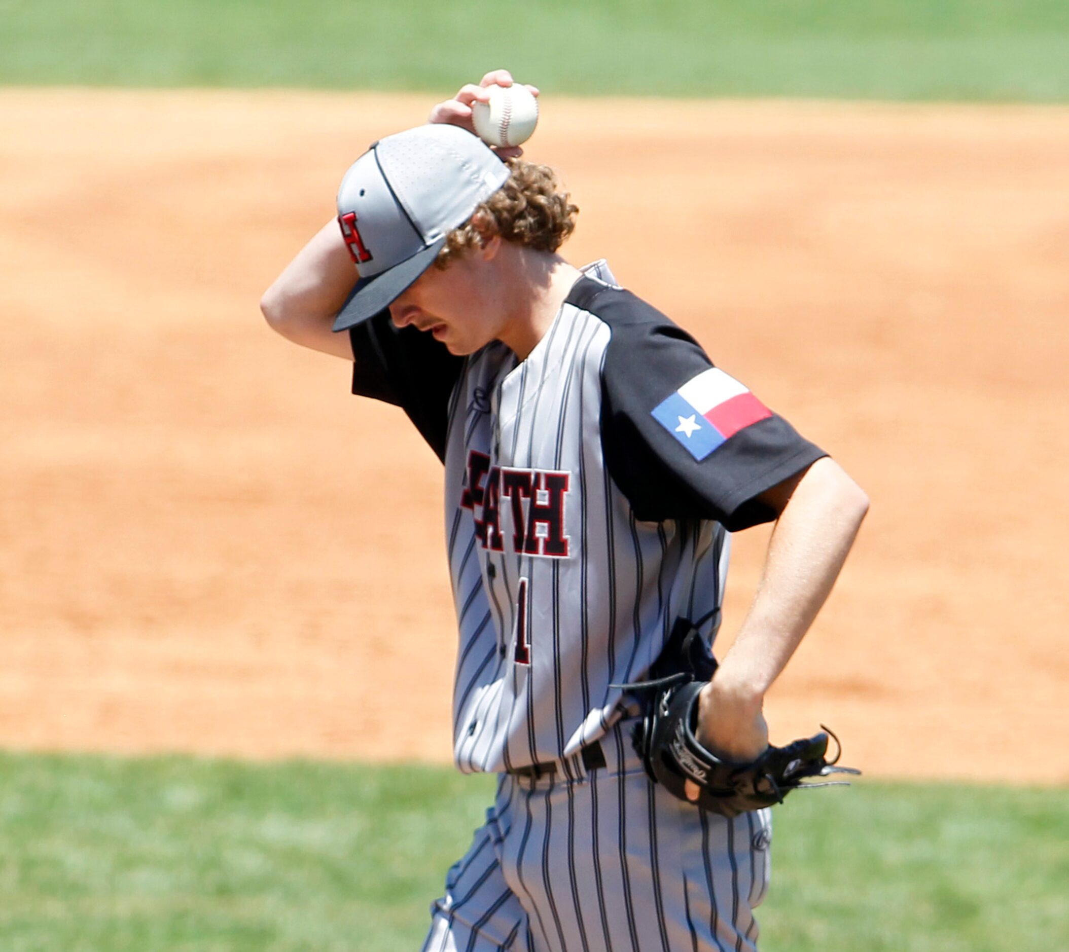 Rockwall Heath pitcher Baylor Baumann (1) collects his thoughts between batters during the...