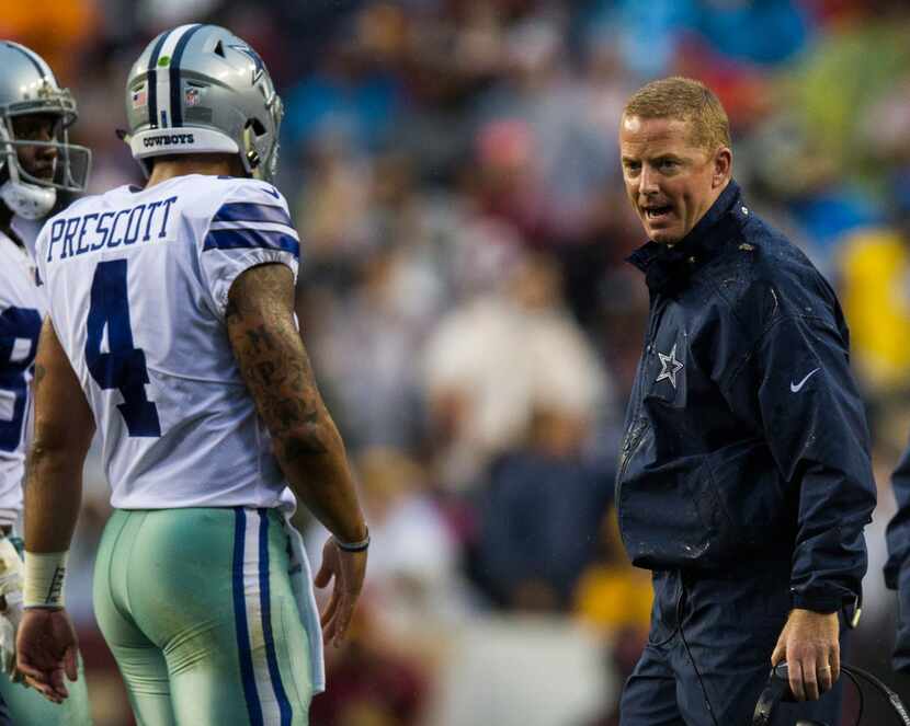 Dallas Cowboys head coach Jason Garrett talks to quarterback Dak Prescott (4) as he walks...