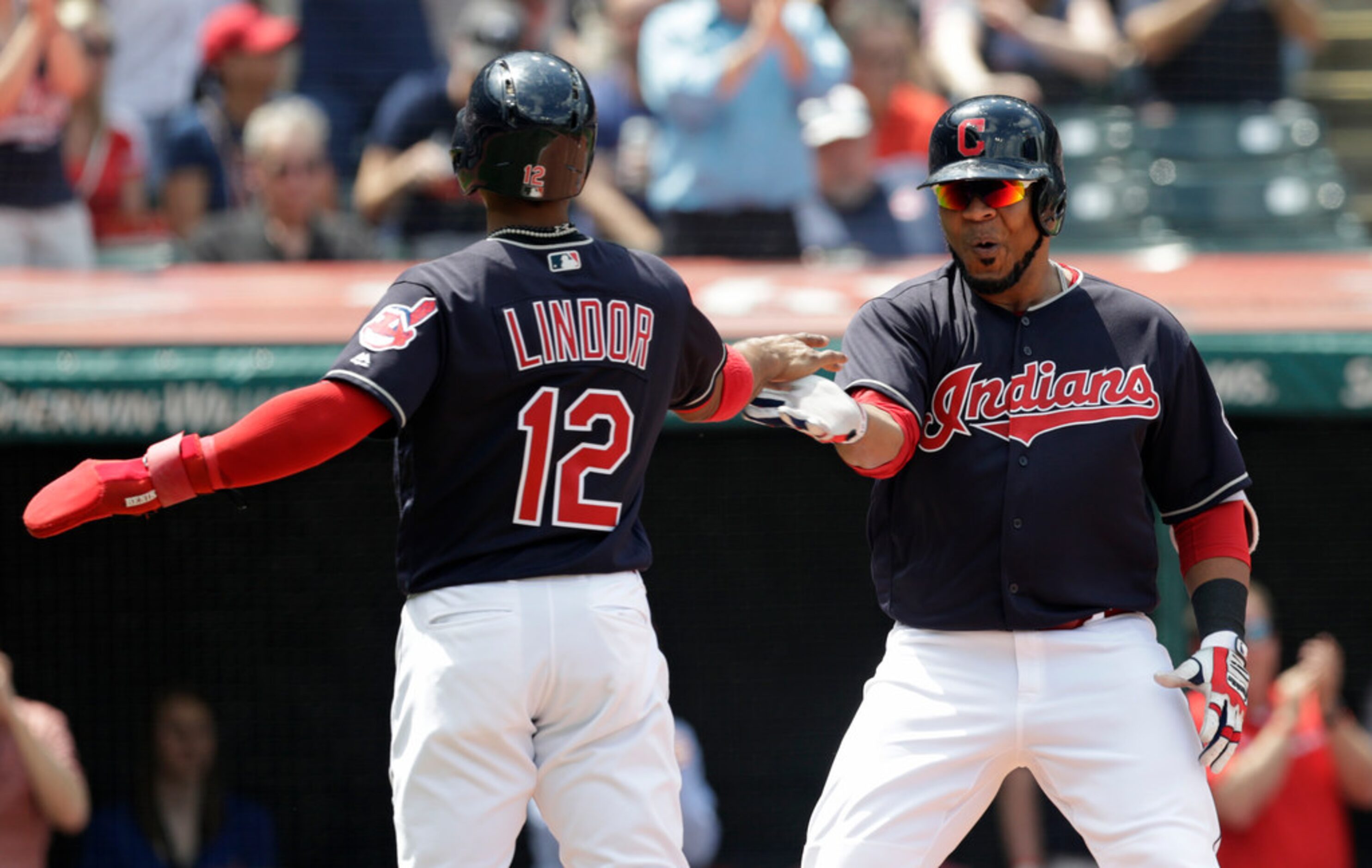 Cleveland Indians' Edwin Encarnacion, right, is congratulated by Francisco Lindor after...