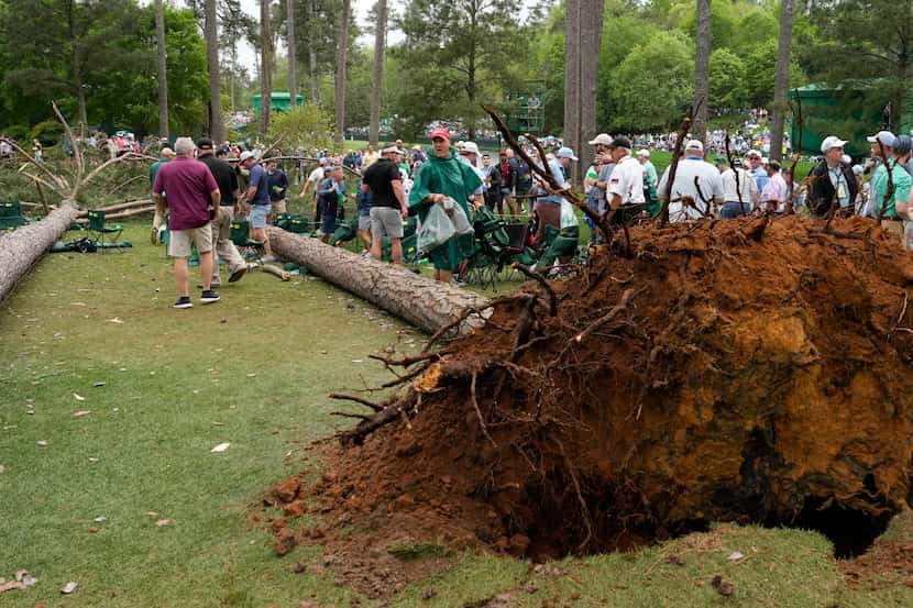 Patrons depart the course after trees blew over on the 17th hole during the second round of...