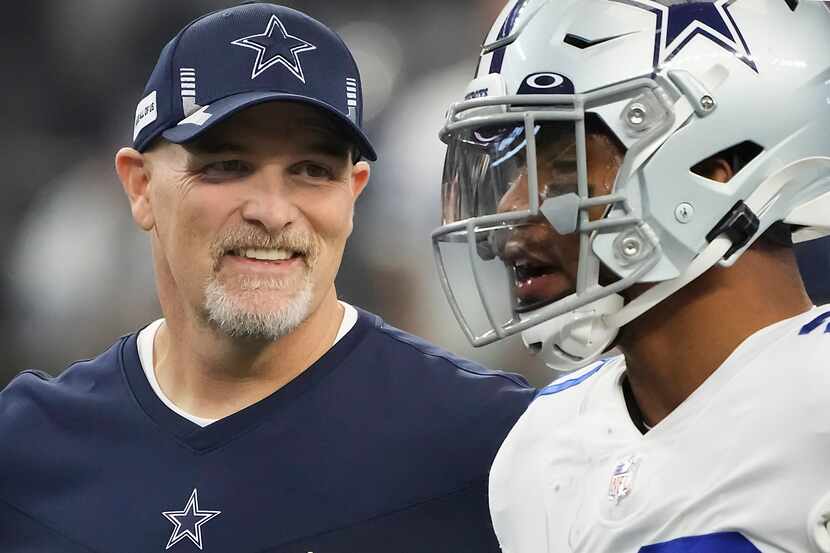 Dallas Cowboys defensive coordinator Dan Quinn talks with running back Tony Pollard as the...