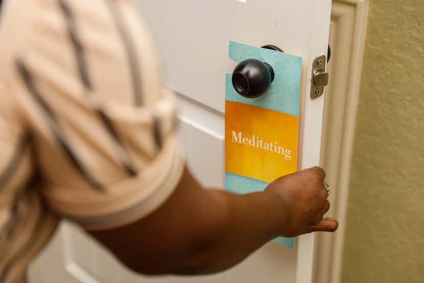 Ayana Brown, a Navy veteran, hangs a "Meditating" notice on the door nob of her meditation...
