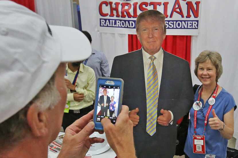 Doug Hershey takes a photo of Lisa Brown, both from Amarillo, with a cutout of President...