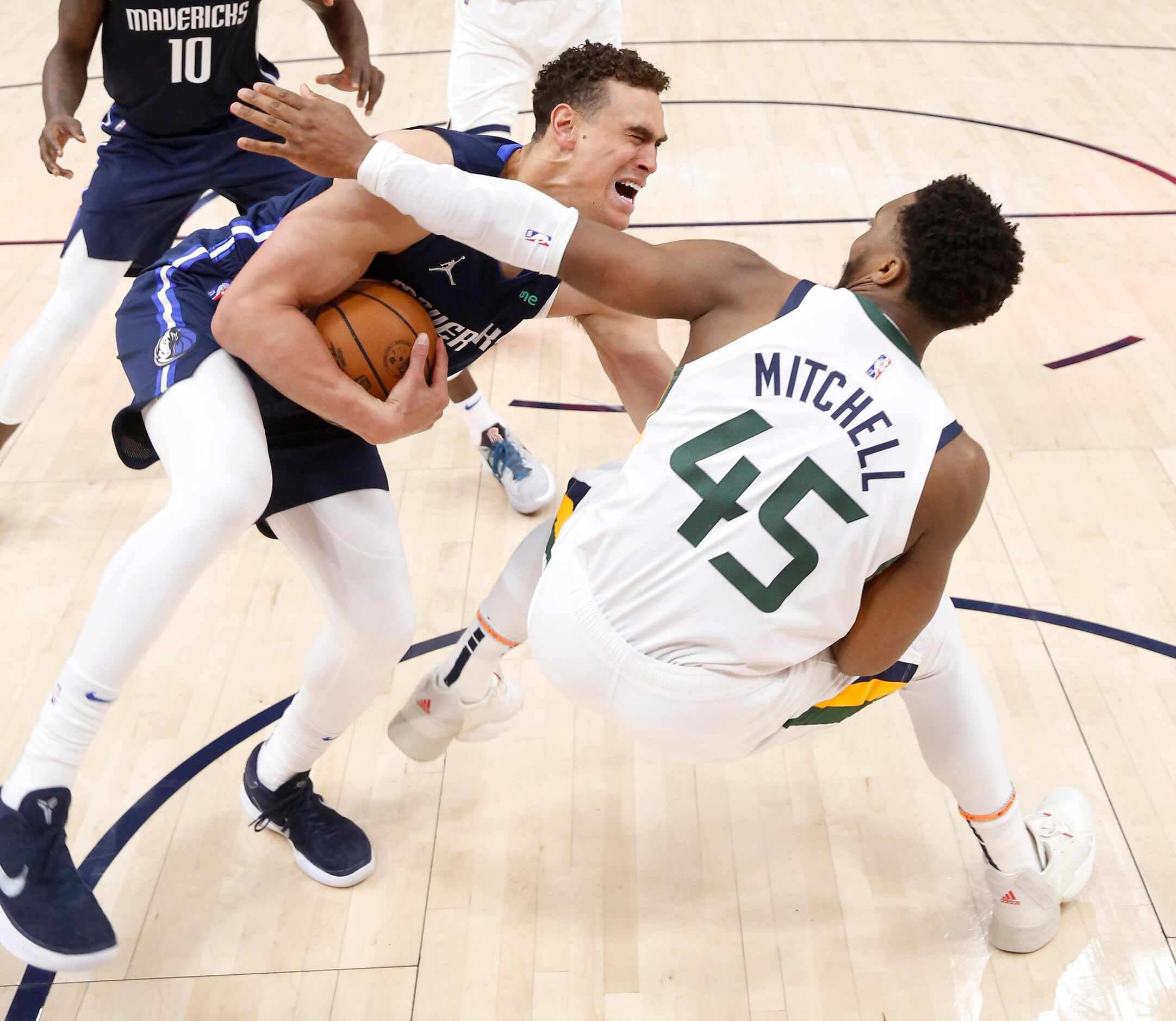 Dallas Mavericks center Dwight Powell (7) is fouled by Utah Jazz guard Donovan Mitchell (45)...