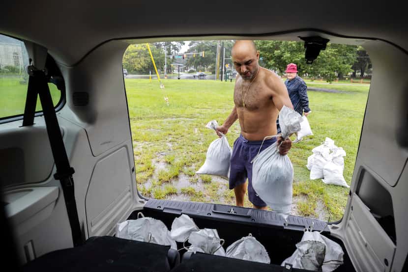Savannah resident Roi Roizaken loads sandbags into his van as rain from Hurricane Debby...
