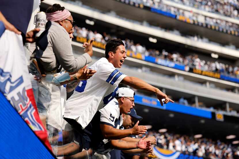 Dallas Cowboys fans go crazy for their players as they walk off the field with a win against...