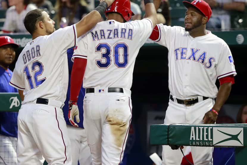 Texas Rangers right fielder Nomar Mazara (30) is greeted at the dugout by Texas Rangers...