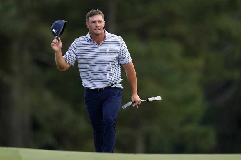 Bryson DeChambeau arrives on the 18th green during the first round at the Masters golf...