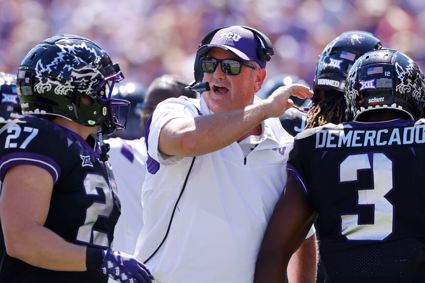 TCU head coach Sonny Dykes celebrates with his players after TCU scored a touchdown against...