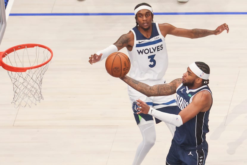 Dallas Mavericks guard Jaden Hardy (front) drives to the basket past Minnesota Timberwolves...