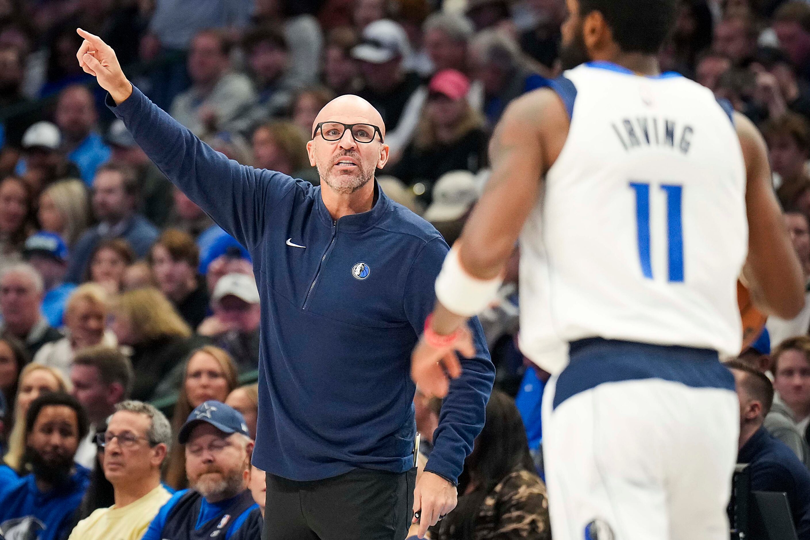 Dallas Mavericks head coach Jason Kidd calls in a play to guard Kyrie Irving (11) during the...