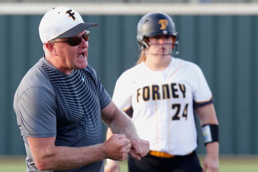 Forney softball coach Pat Eitel gives instruction to a batter with Sadie Hewitt (24) on...