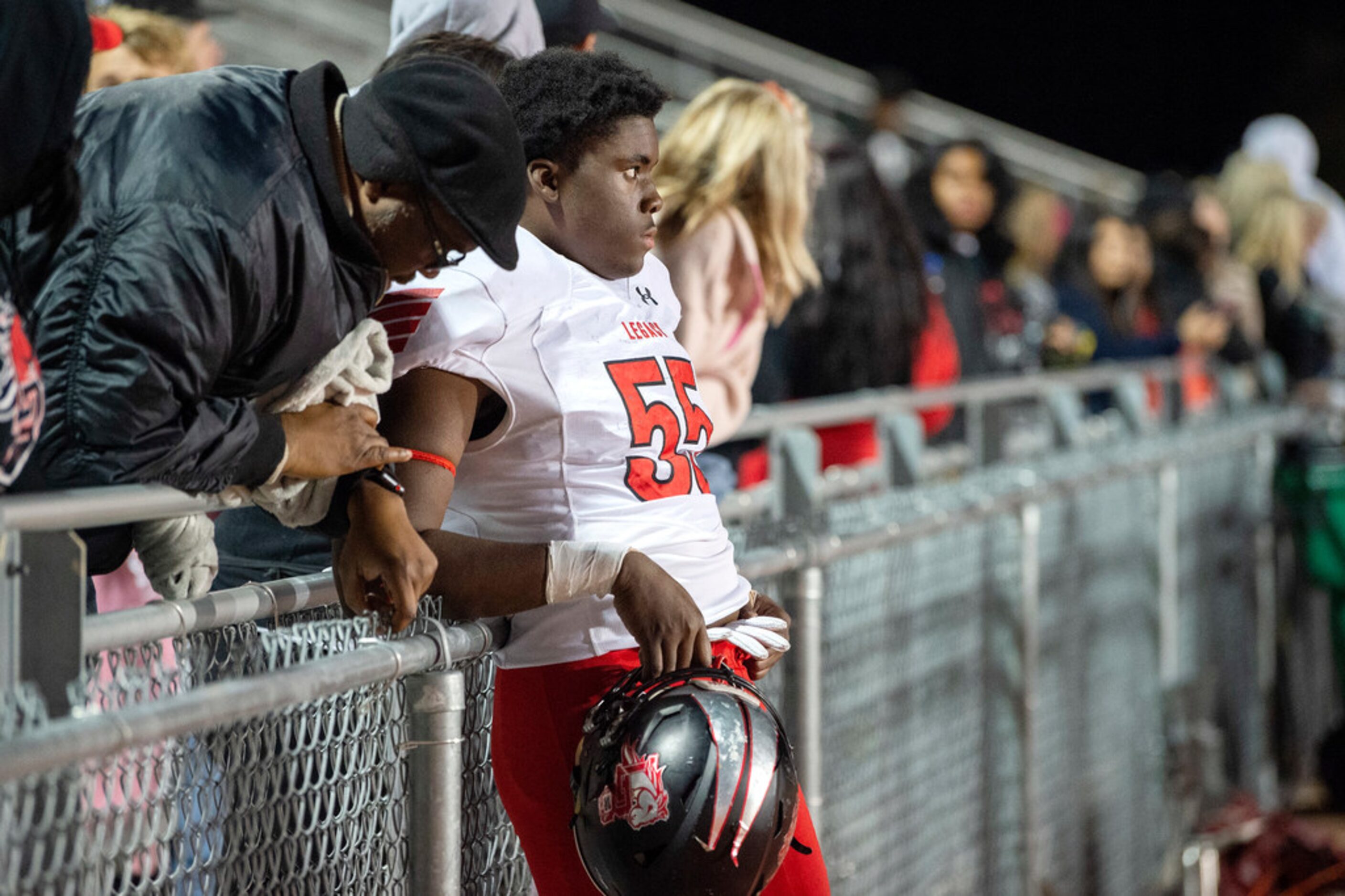 Mansfield Legacy defensive lineman David Abiara (55) watches dejectedly from the sidelines...