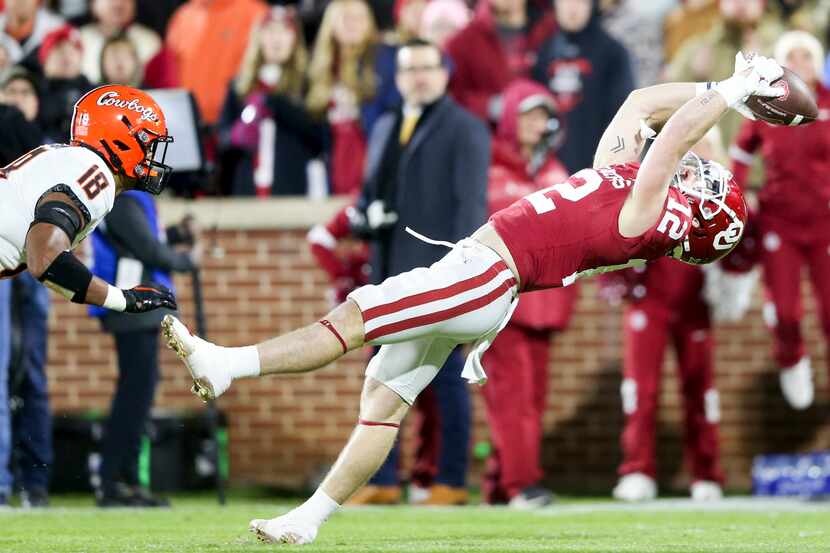 Oklahoma wide receiver Drake Stoops (12) catches a pass while Oklahoma State safety Sean...