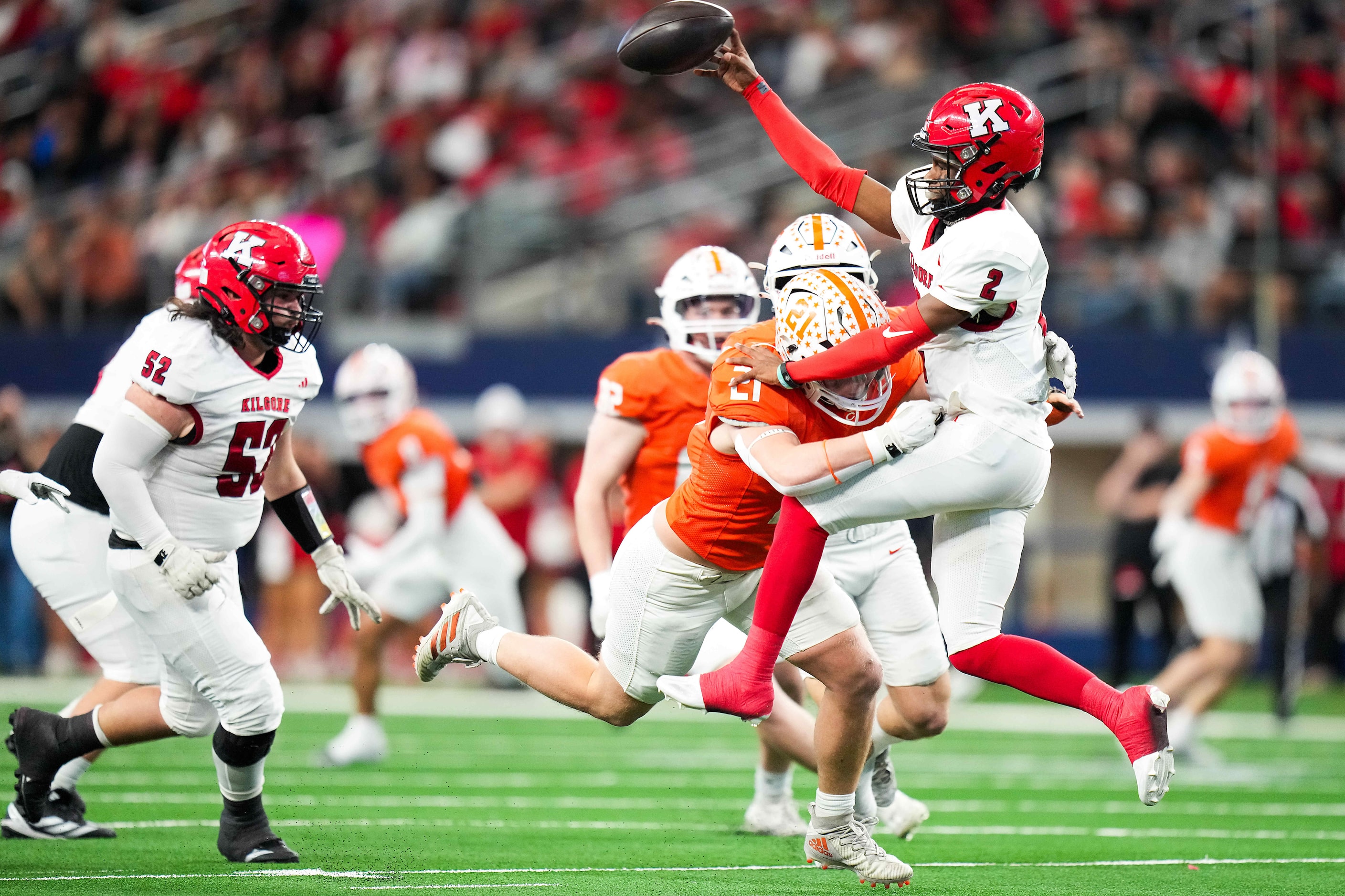 Kilgore's Kayson Brooks (2) gets off a pass as he is hit by Celina's Ronnie Foreman (21)...