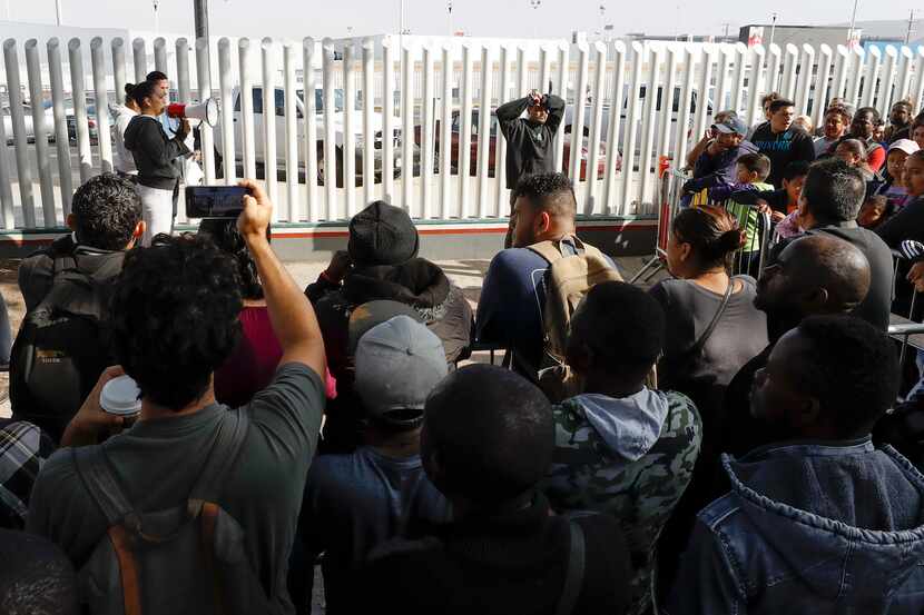 Una mujer habla a migrantes que quieren solicitar asilo en Estados Unidos  en Tijuana,...