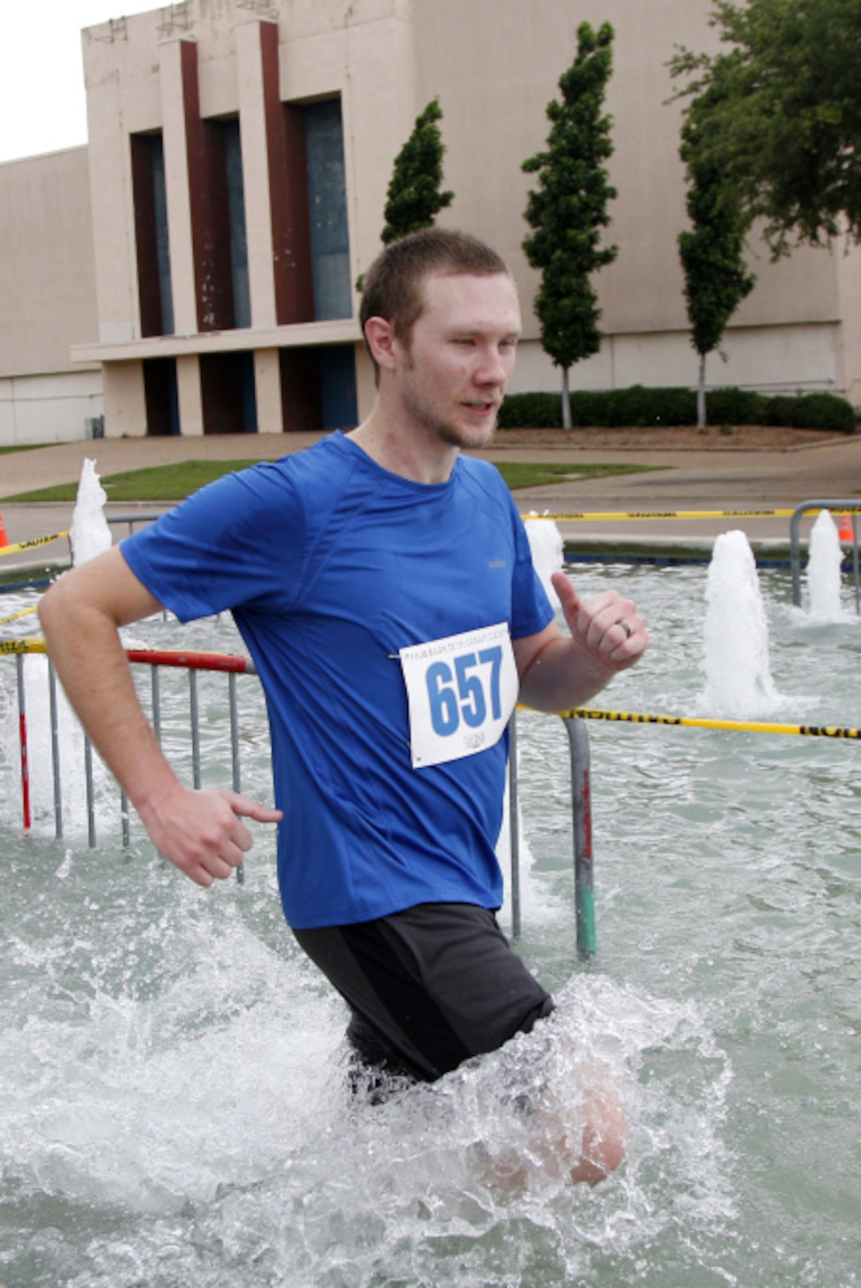 Adam Stockton runs in a fountain during the Second Annual Fair Park 5K Urban Dash Saturday...