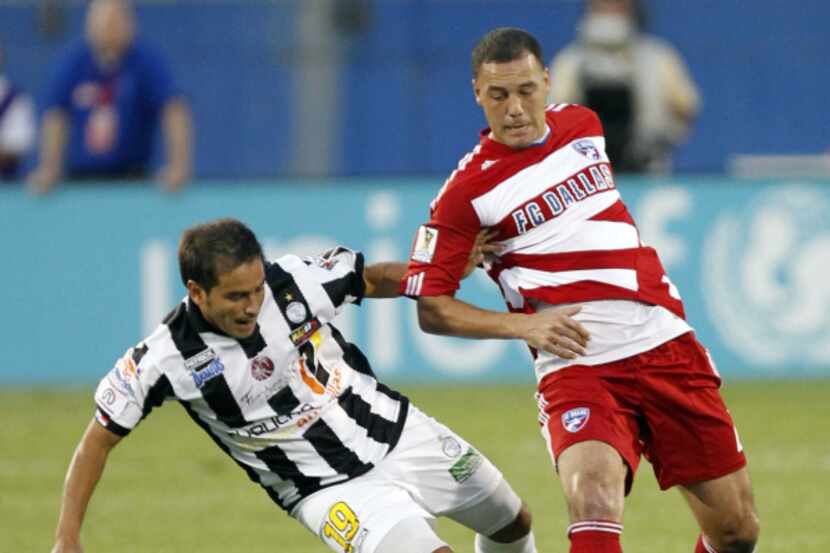Daniel Hernández, del FC Dallas (derecha),  pasa el balón a un compañero de equipo mientras...