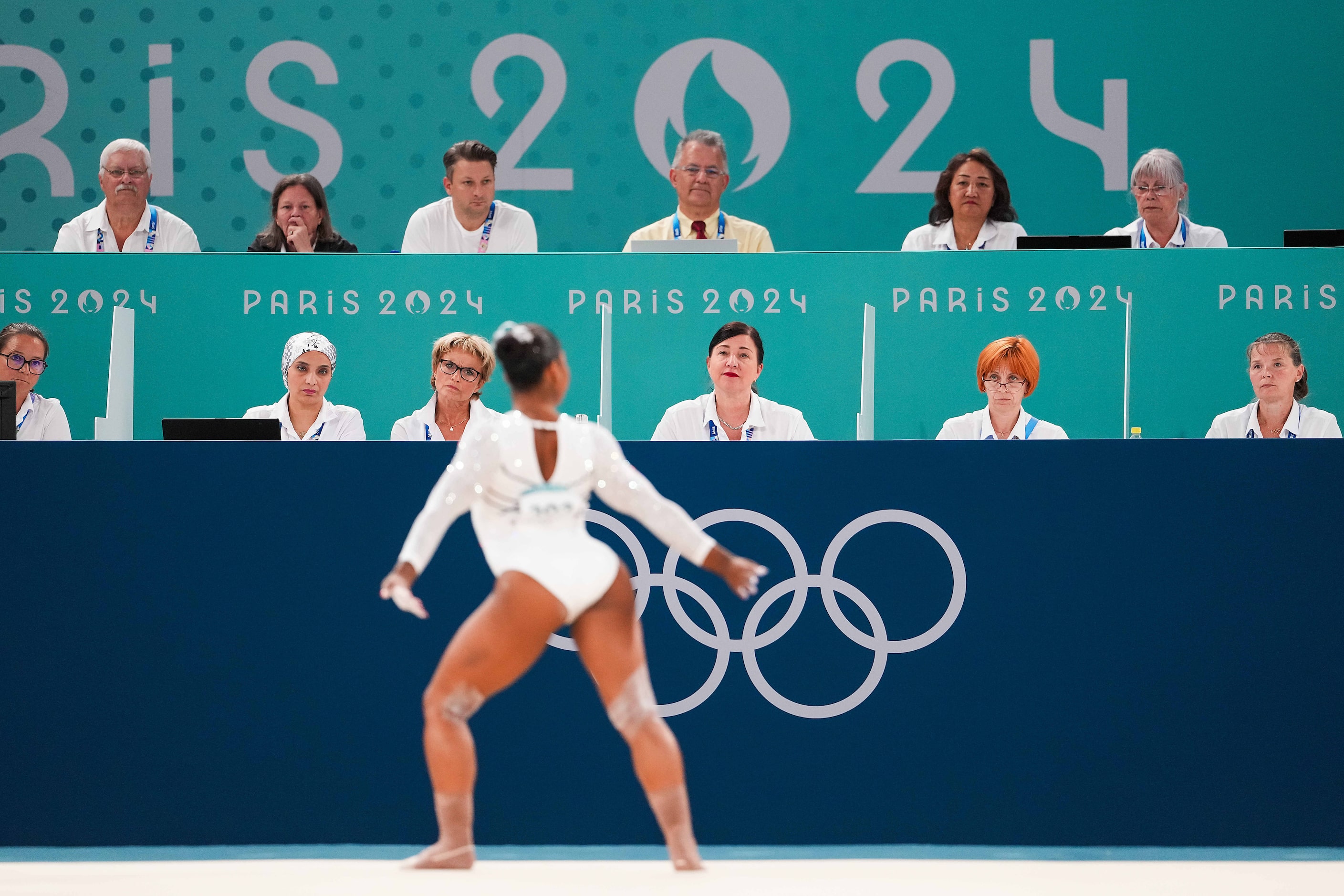 Judges look on as Jordan Chiles of the United States competes in the women’s floor exercise...