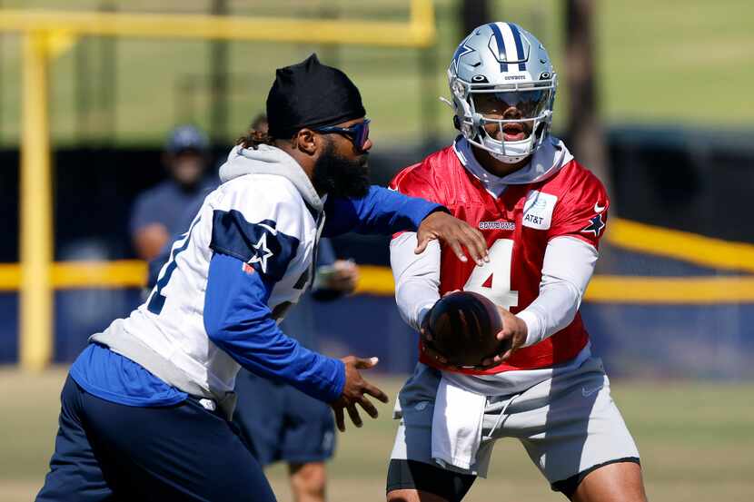 Dallas Cowboys quarterback Dak Prescott (4) hands the football off to running back Ezekiel...