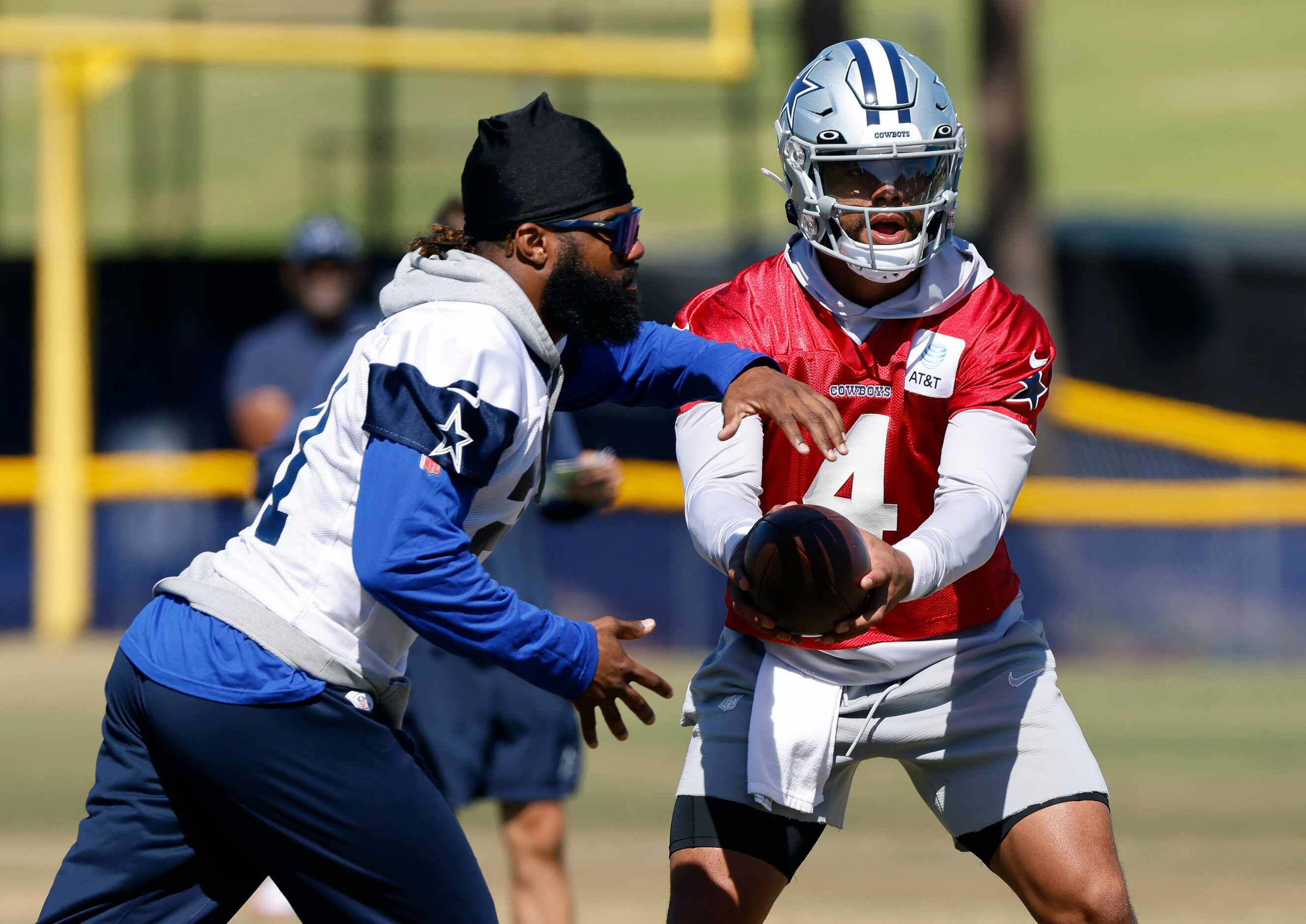 Dallas Cowboys quarterback Dak Prescott (4) hands the football off to running back Ezekiel...