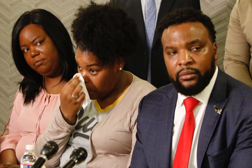 Amber Carr, center, wipes a tear as her sister, Ashley Carr, left, and attorney Lee Merritt,...
