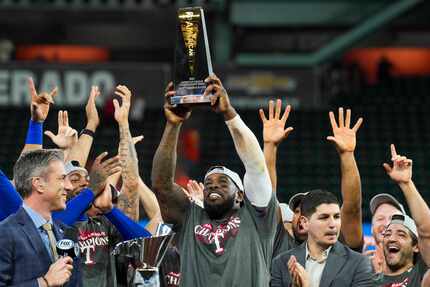 Texas Rangers right fielder Adolis Garcia  hoists the ALCS MVP trophy after defeating the...