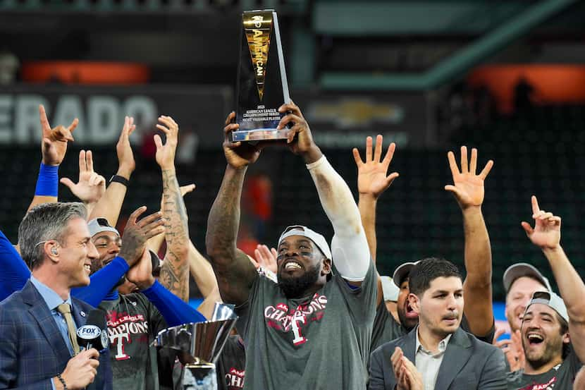 Texas Rangers right fielder Adolis Garcia  hoists the ALCS MVP trophy after defeating the...