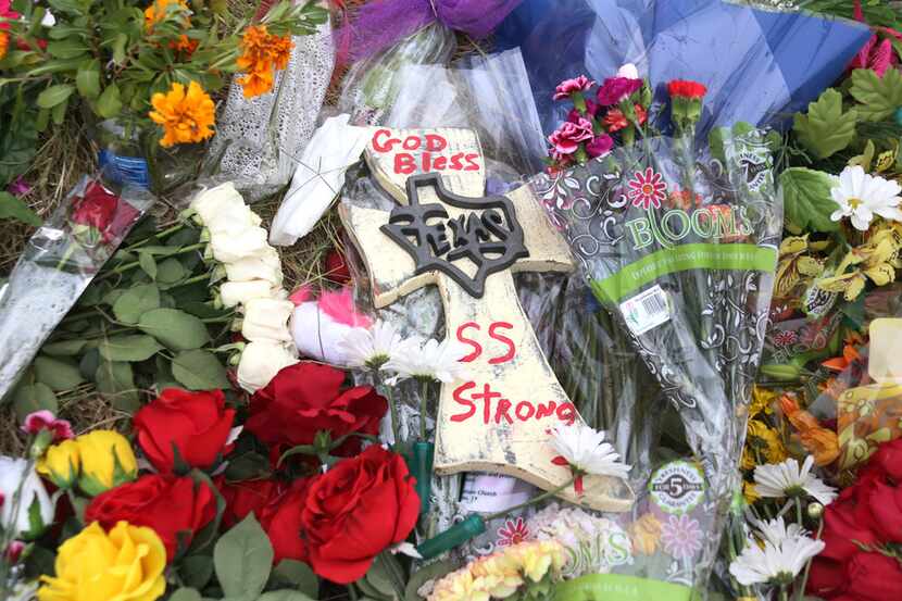 Flowers and other items are placed at a memorial near the site of the massacre at First...