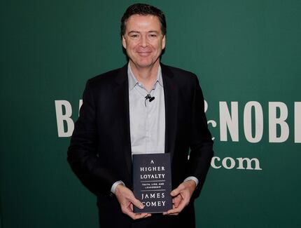 Former FBI Director James Comey poses for photographs at a Barnes & Noble book store before...