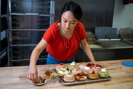 Jinny Cho, owner of Detour Doughnuts and Coffee, puts finishing touches on assorted...