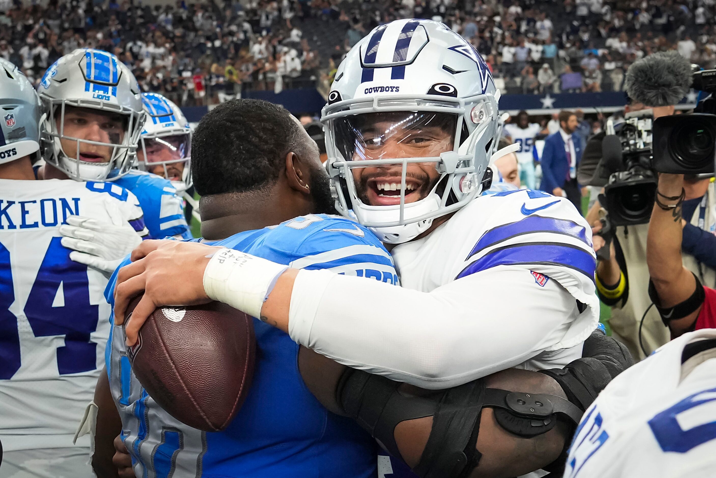 Dallas Cowboys quarterback Dak Prescott (4) hugs Detroit Lions defensive end Isaiah Buggs...