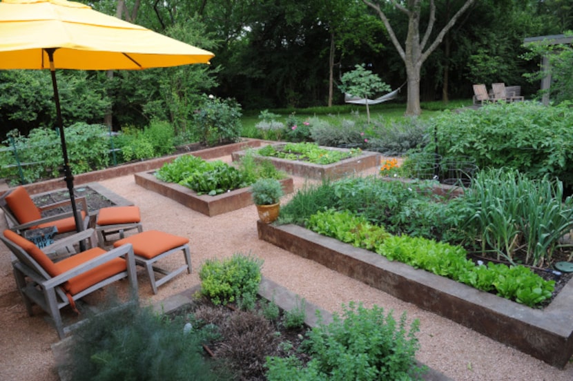 The backyard of Lisa Domiteaux and her husband Mark features order raised vegetable beds, a...