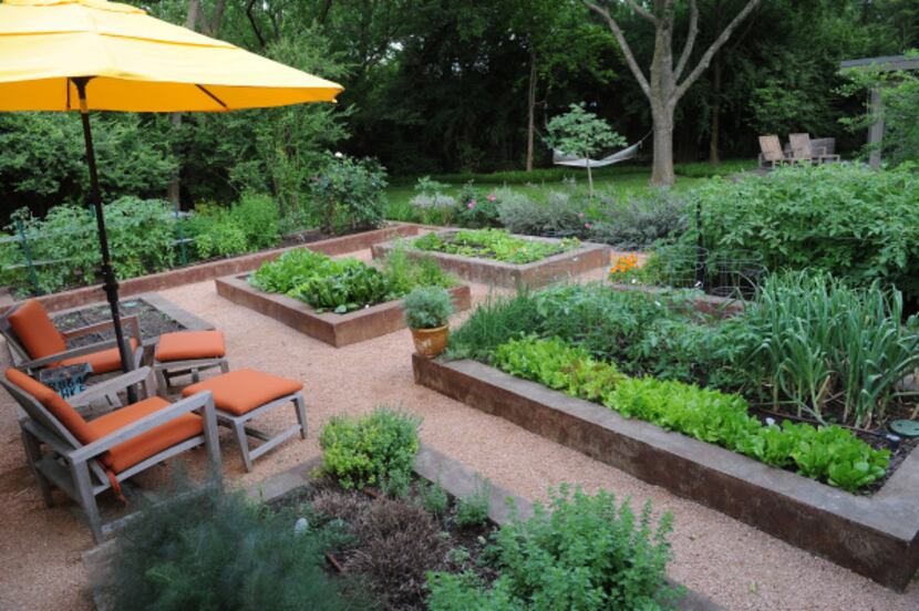 The backyard of Lisa Domiteaux and her husband Mark features order raised vegetable beds, a...