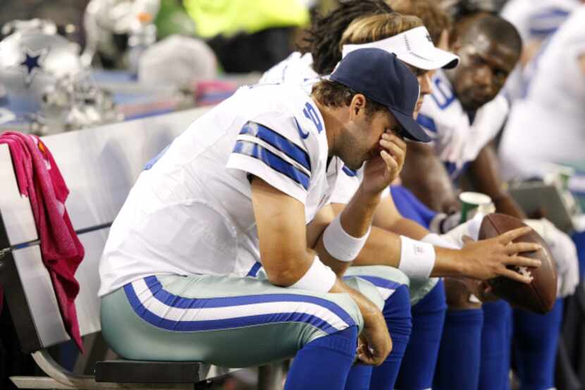 Dallas Cowboys quarterback Tony Romo (9) dejected on the bench after his fourth...