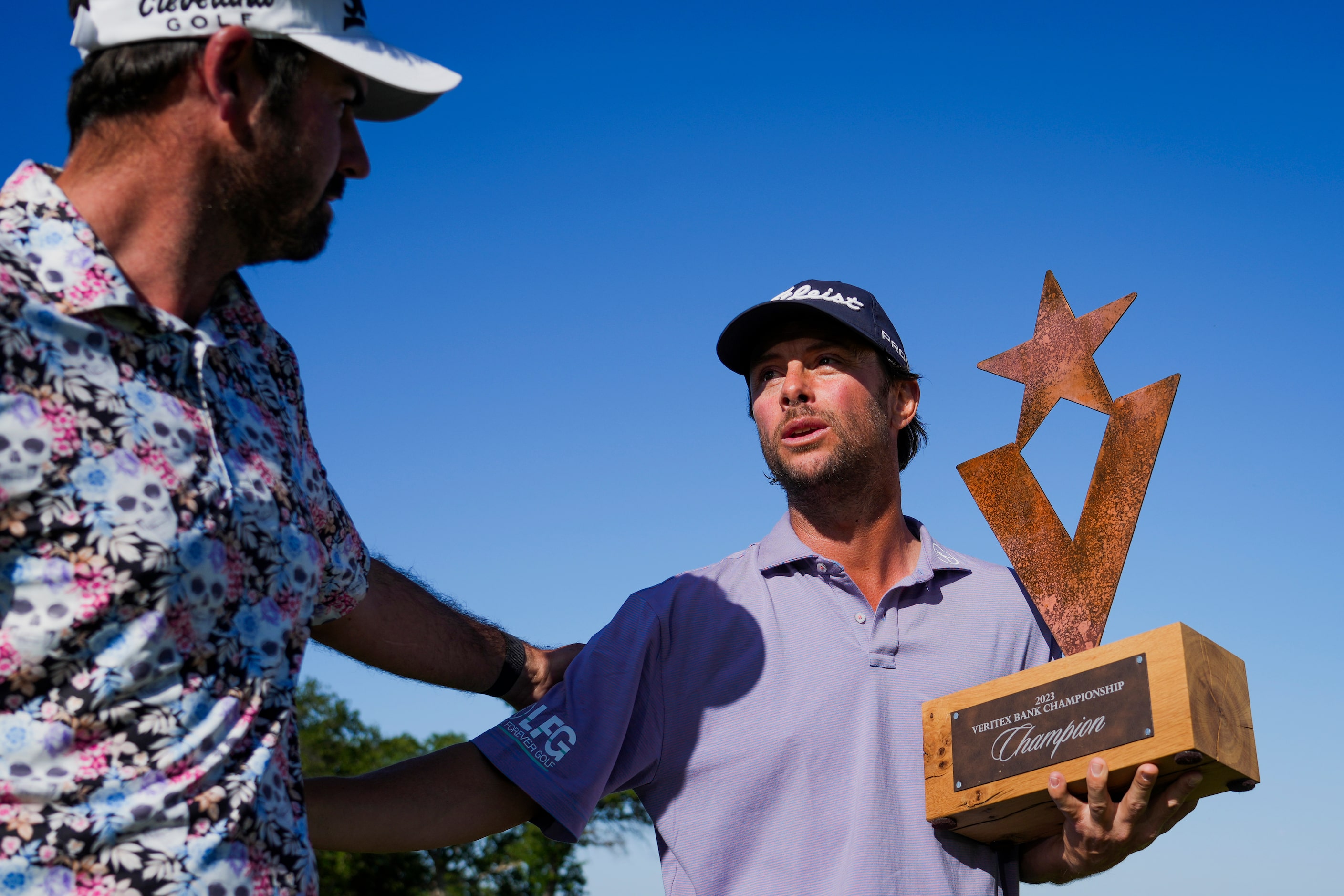 Spencer Levin holds the trophy as he is congratulated by Brett Drewitt after winning the...