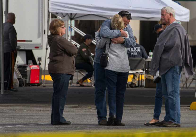 Burlington Mayor Steve Sexton hugs one of the victims' family members outside Cascade Mall.