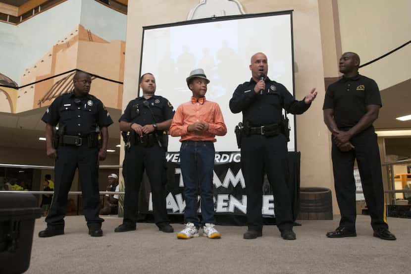 
With Isaac Cherry, 14, facilitating, Dallas Police Officers Cory Anderson, far left, Daniel...