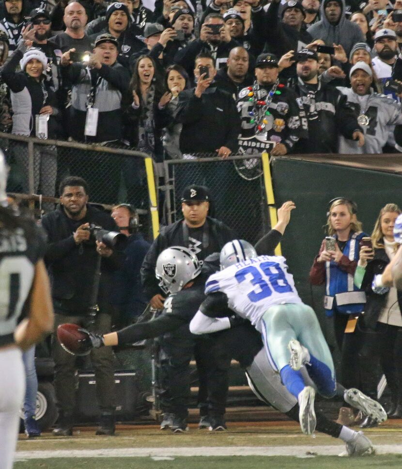 Oakland Raiders quarterback Derek Carr (4) reaches out for the goal line as he's hit by Jeff...