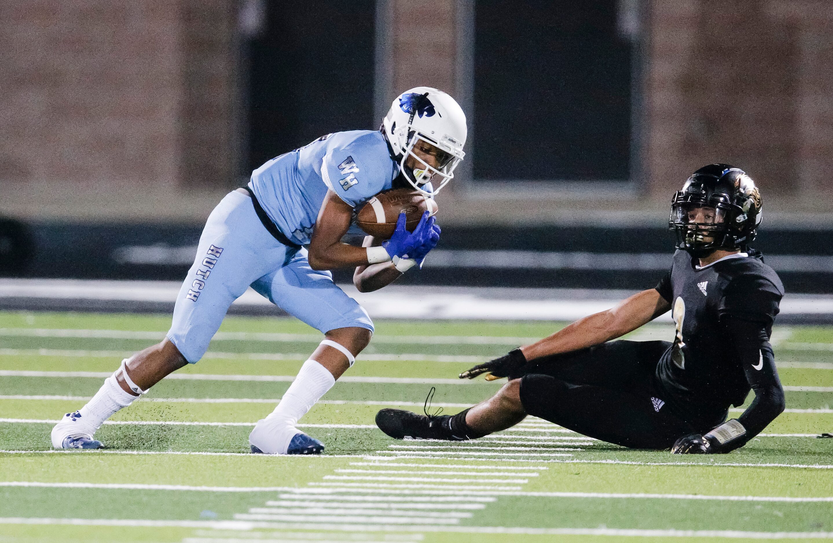 Wilmer-Hutchins junior defensive back Jakyri Moore, left, intercepts a pass during the first...