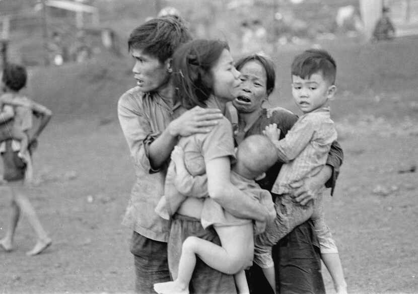Civilians huddle after an attack by South Vietnamese forces in Dong Xoai, June 1965.