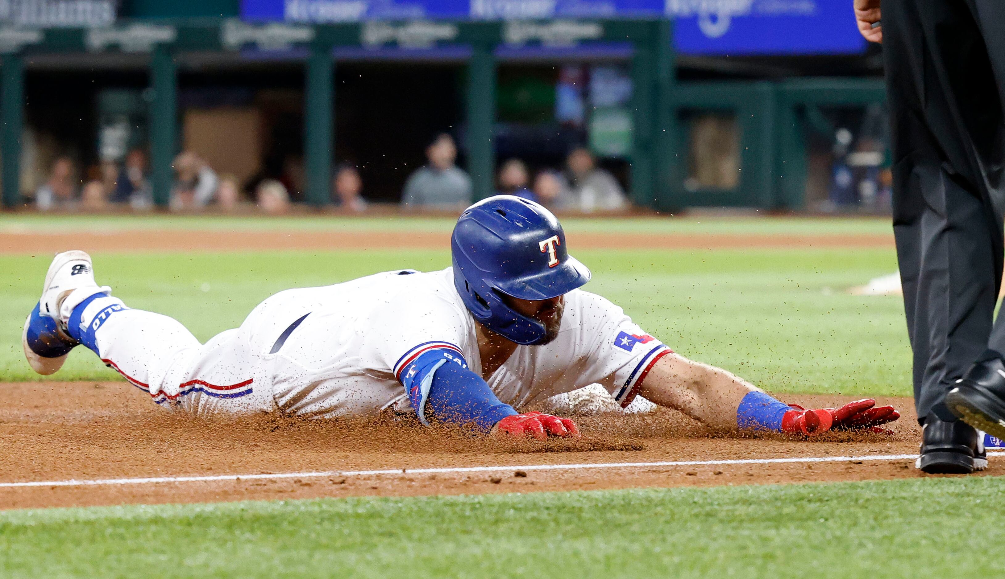 Texas Rangers Joey Gallo (13) slides head first into third after hitting a double down the...