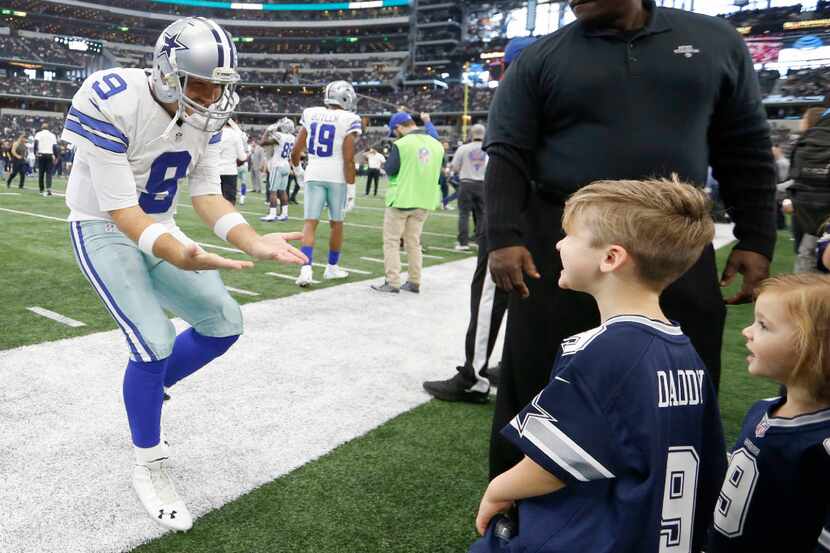 Dallas Cowboys quarterback Tony Romo (9) rushes to talk to his kids Hawkins and Rivers Romo ...