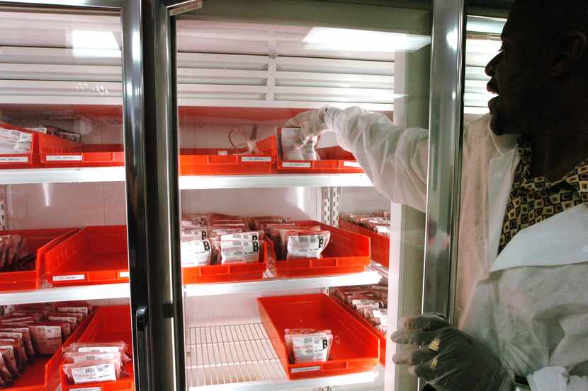 Hospital technician Gregory Whitehead adjusts dwindling supplies of blood on the shelves at...