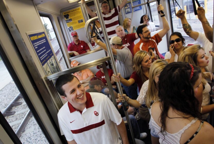 Sooner fan Alex Solomon (left) said he thought riding DART to the game was cheaper than...