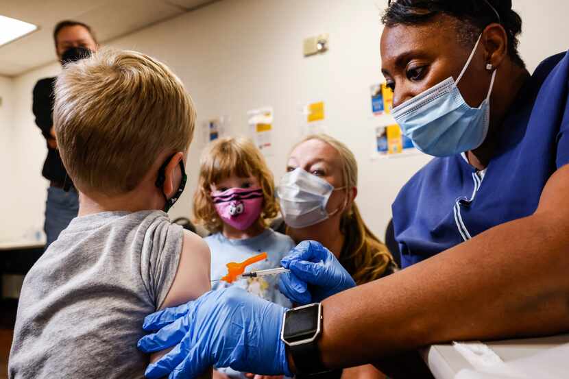 La enfermera Barbara Davis administra una vacuna de covid-19 a Robert Holt, de 5 años, en...