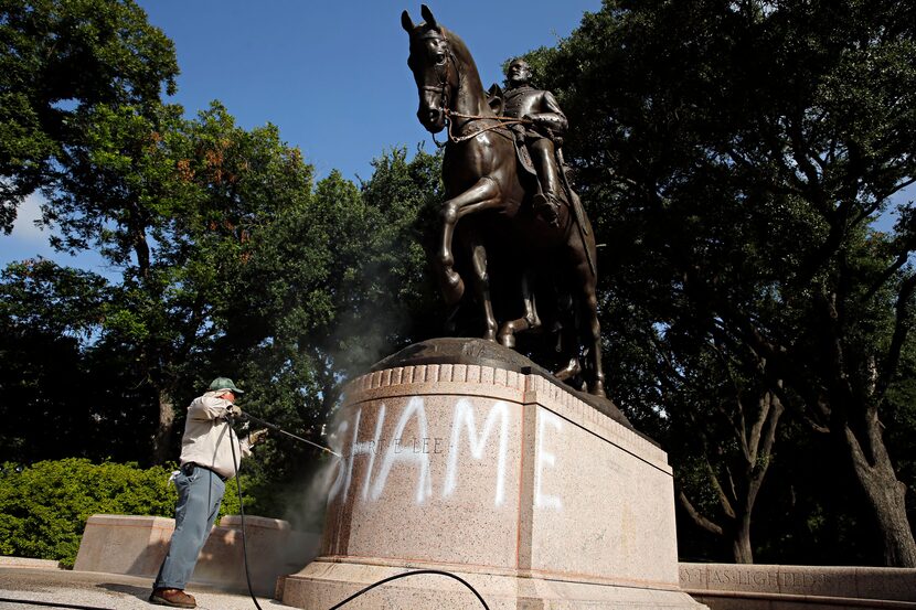 Tino Banda with the Dallas Park and Recreation Department used a power washer to remove the...